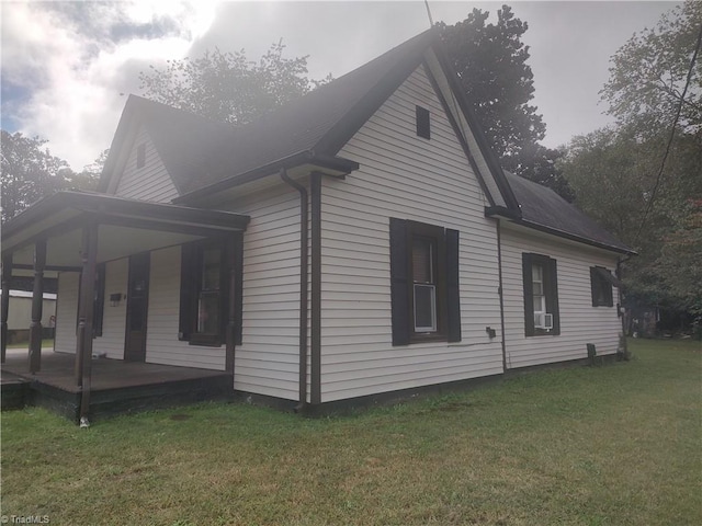 view of side of property featuring a porch and a lawn