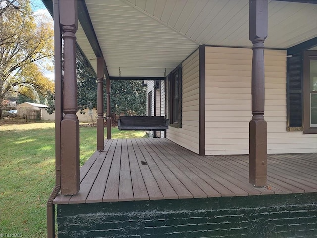 deck featuring covered porch and a yard