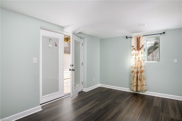 empty room with dark wood-style floors and baseboards