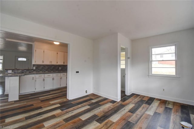 kitchen with white cabinetry, backsplash, and dark hardwood / wood-style floors