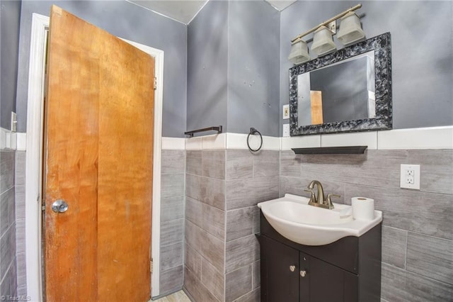 bathroom featuring vanity and tile walls