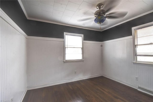 empty room featuring crown molding, dark hardwood / wood-style floors, and ceiling fan