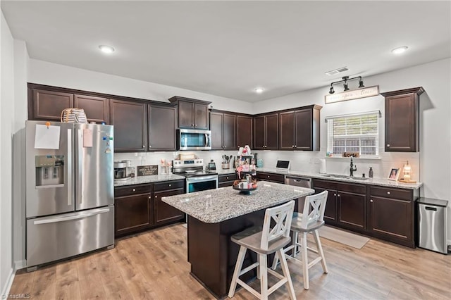 371 Royce Dr, Winston-Salem, NC 27107 - kitchen with stainless steel appliances, dark brown cabinetry, light stone counters, and a sink