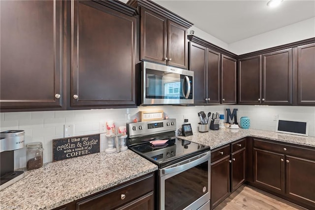 371 Royce Dr, Winston-Salem, NC 27107 - kitchen with dark brown cabinetry, appliances with stainless steel finishes, light stone counters, and tasteful backsplash