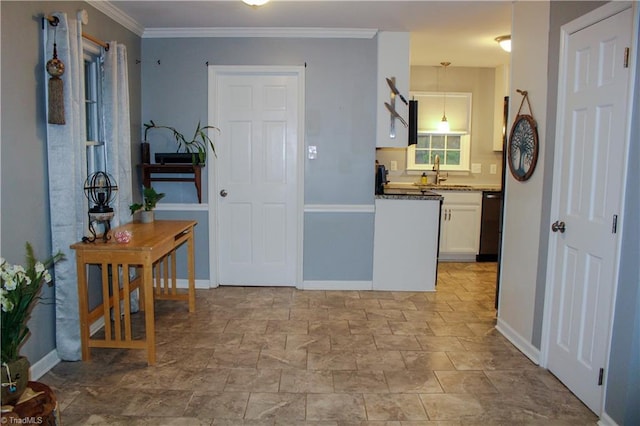 4503 Radnor Dr, Greensboro, NC 27410 - kitchen featuring white cabinetry, a sink, decorative light fixtures, baseboards, and ornamental molding