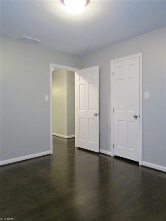 4503 Radnor Dr, Greensboro, NC 27410 - spare room with baseboards and dark wood-style flooring