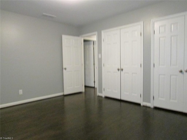 4503 Radnor Dr, Greensboro, NC 27410 - unfurnished bedroom featuring baseboards, dark wood-type flooring, and a closet