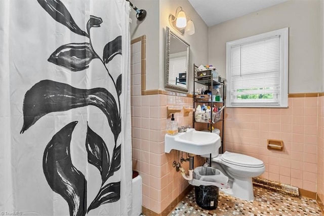 803 Buckner St, Graham, NC 27253 - full bath featuring tile walls, a wainscoted wall, shower / bathtub combination with curtain, and tile patterned flooring