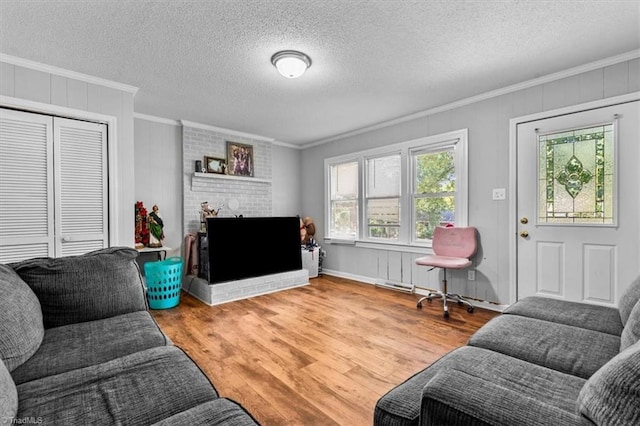 803 Buckner St, Graham, NC 27253 - living area featuring crown molding, wood finished floors, a fireplace, and a textured ceiling