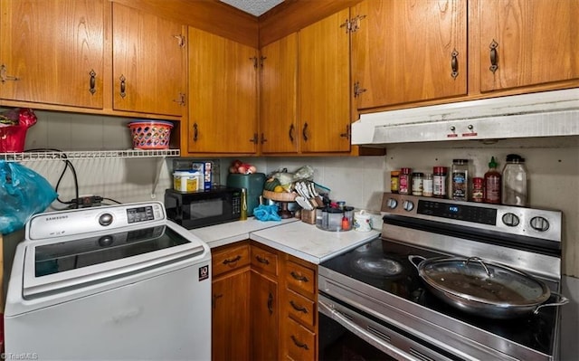 803 Buckner St, Graham, NC 27253 - kitchen with stainless steel range with electric stovetop, washer / dryer, black microwave, light countertops, and brown cabinetry