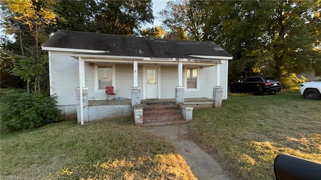 bungalow-style house with a porch and a front lawn