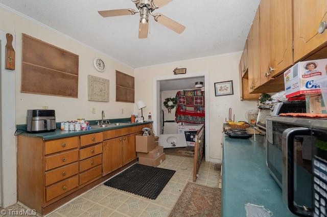 kitchen featuring ceiling fan, crown molding, light tile patterned floors, and sink