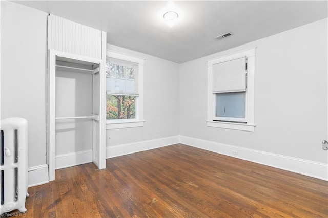 unfurnished bedroom with dark hardwood / wood-style floors and a closet