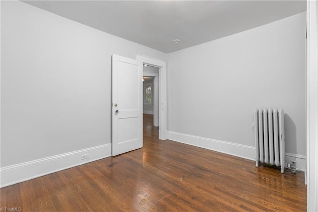 empty room featuring dark hardwood / wood-style floors and radiator