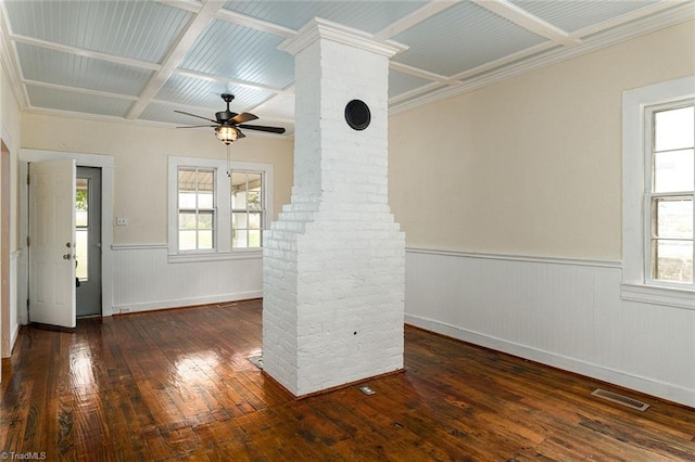 empty room with ceiling fan, coffered ceiling, plenty of natural light, and dark wood-type flooring