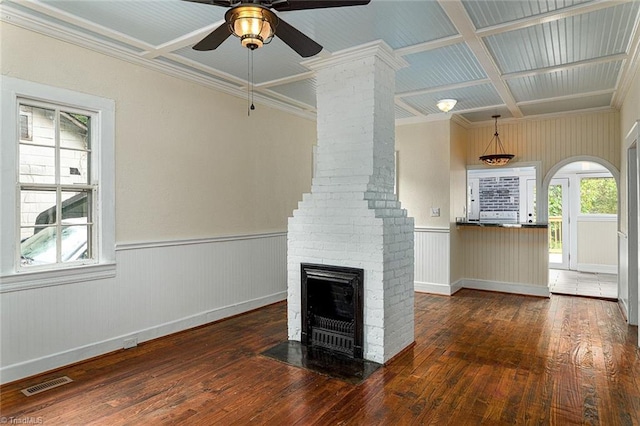 unfurnished living room with coffered ceiling, a brick fireplace, ceiling fan, ornamental molding, and dark hardwood / wood-style floors