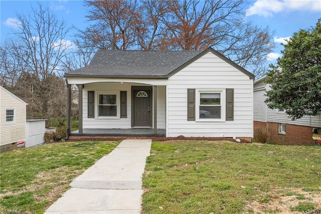 bungalow-style house featuring a front yard, covered porch, and a shingled roof