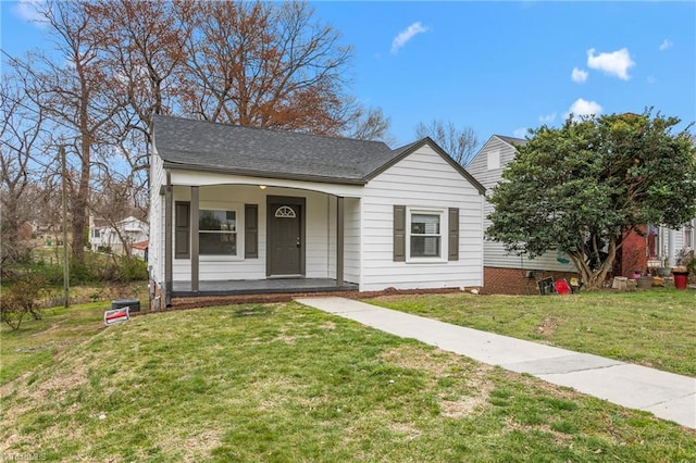 view of front of house featuring a front lawn, covered porch, and roof with shingles