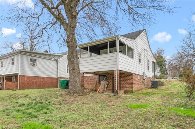 view of side of property with brick siding, a lawn, and cooling unit