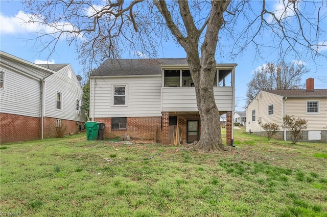 back of property with a lawn and a sunroom