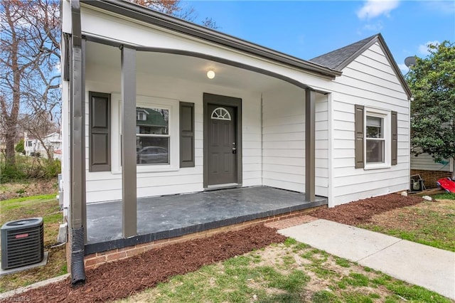 entrance to property featuring covered porch and central AC