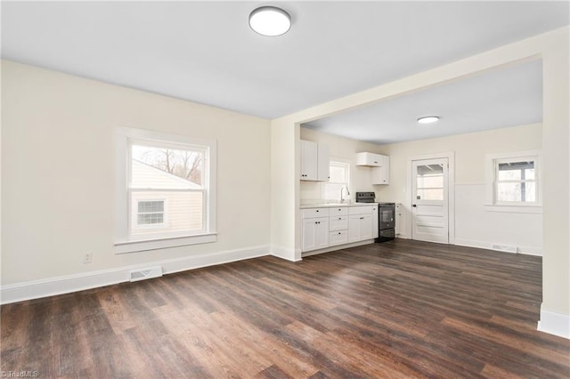 unfurnished living room featuring dark wood finished floors, visible vents, baseboards, and a sink