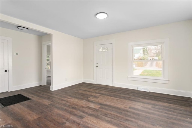 interior space featuring visible vents, baseboards, and dark wood-type flooring