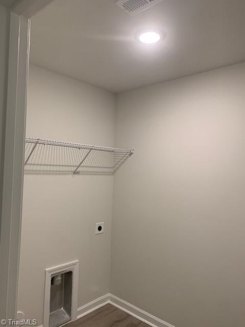 washroom with dark hardwood / wood-style flooring and electric dryer hookup