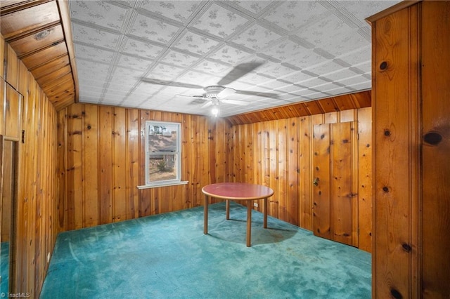 miscellaneous room featuring ceiling fan, carpet floors, and wooden walls