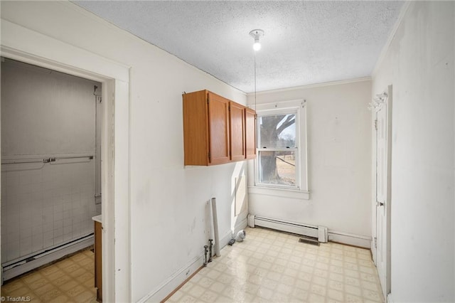 washroom with a baseboard heating unit and a textured ceiling