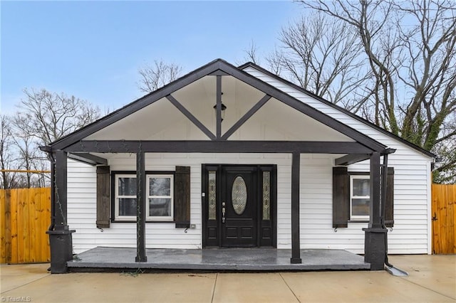 bungalow featuring a porch and fence