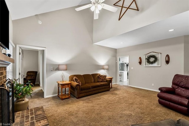 living area featuring ceiling fan, a fireplace, high vaulted ceiling, carpet, and baseboards