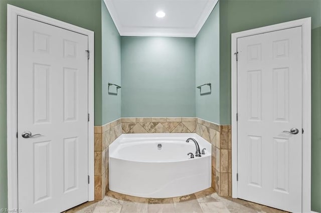 bathroom featuring wainscoting, marble finish floor, tile walls, ornamental molding, and a bath
