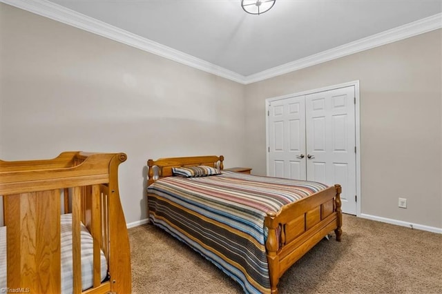 carpeted bedroom with baseboards, ornamental molding, and a closet