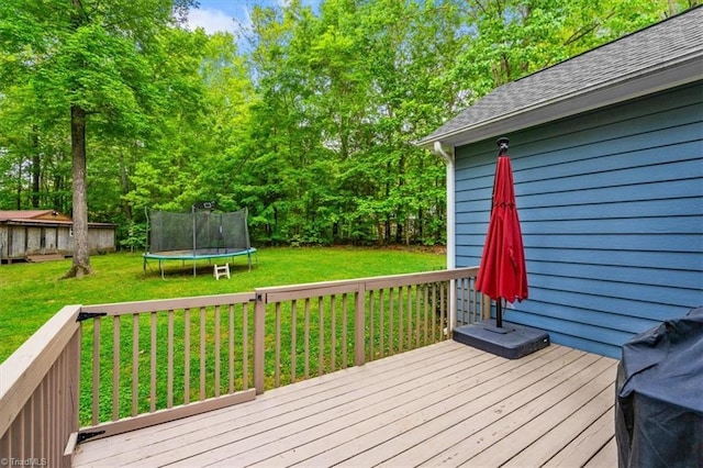 wooden deck featuring a lawn and a trampoline