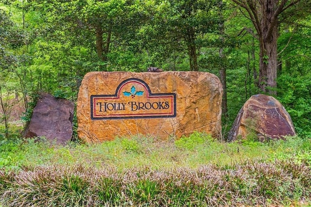 community / neighborhood sign with a forest view