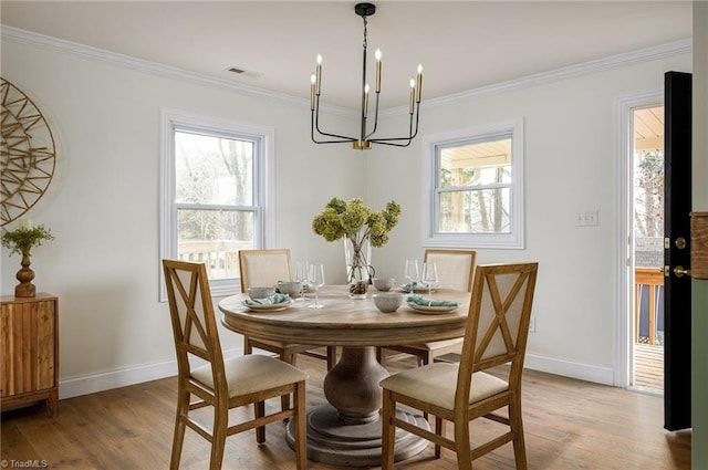 dining space with crown molding, a wealth of natural light, and light wood-type flooring