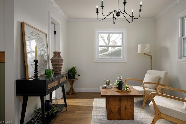 sitting room with a notable chandelier, ornamental molding, and light hardwood / wood-style floors