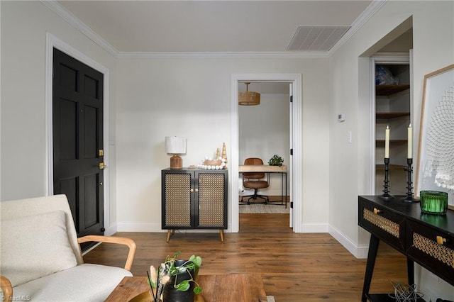 sitting room with crown molding and dark wood-type flooring