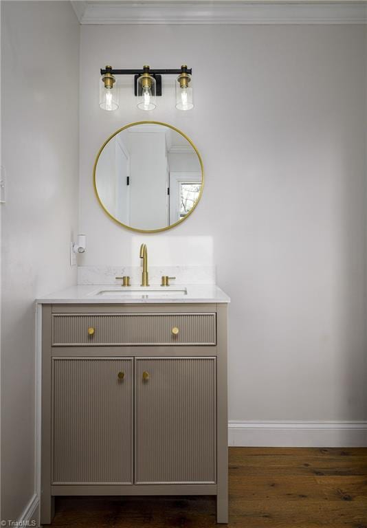 bathroom with crown molding, wood-type flooring, and vanity