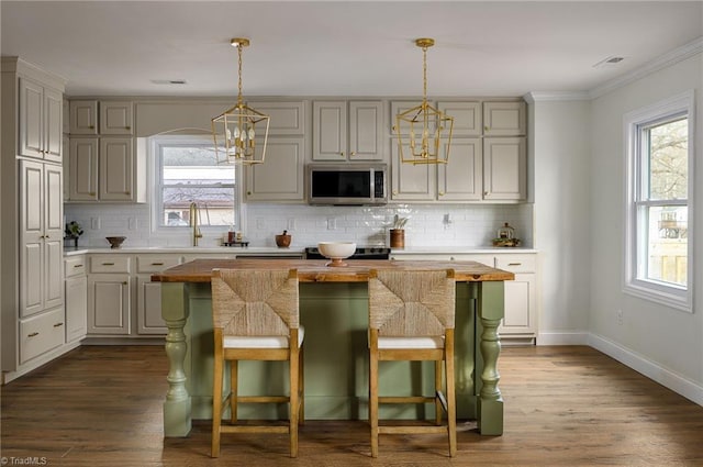 kitchen with a kitchen island, dark hardwood / wood-style flooring, sink, and a breakfast bar area