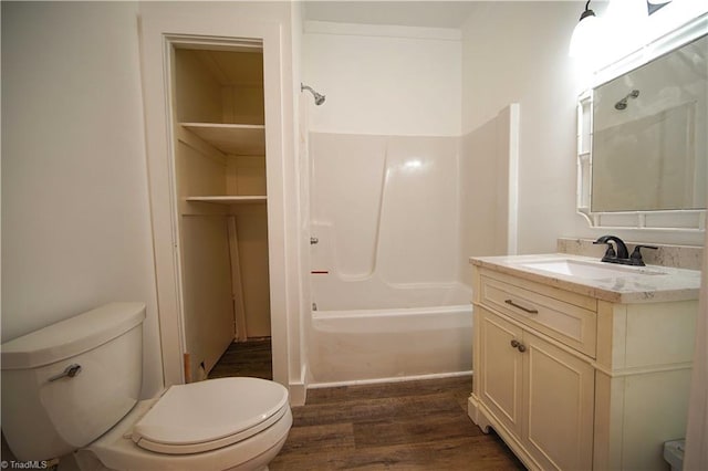 full bathroom with toilet, hardwood / wood-style floors, vanity, and shower / bathtub combination