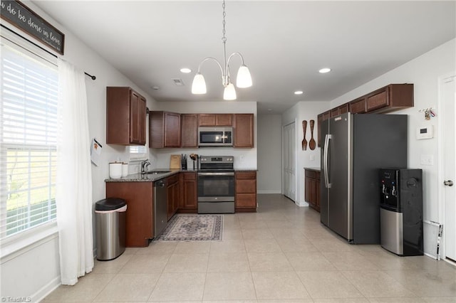 kitchen with pendant lighting, sink, appliances with stainless steel finishes, a notable chandelier, and light tile patterned flooring