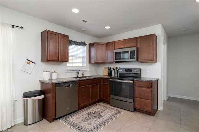 kitchen with light tile patterned floors, stainless steel appliances, and sink