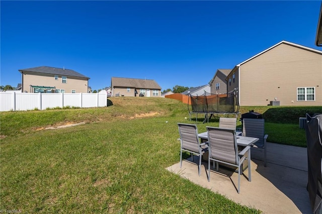 view of yard featuring a patio, a trampoline, and central AC