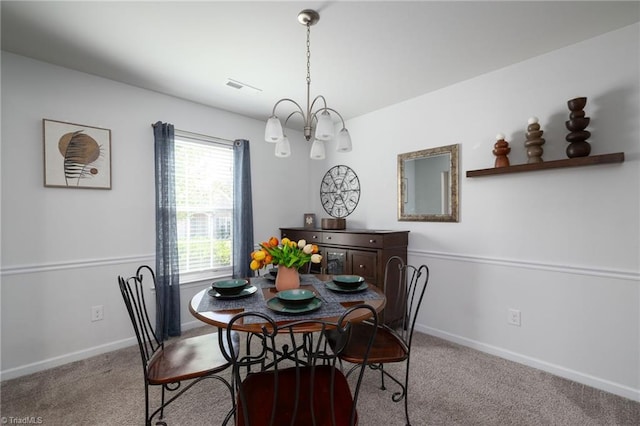 dining area with light colored carpet and a notable chandelier