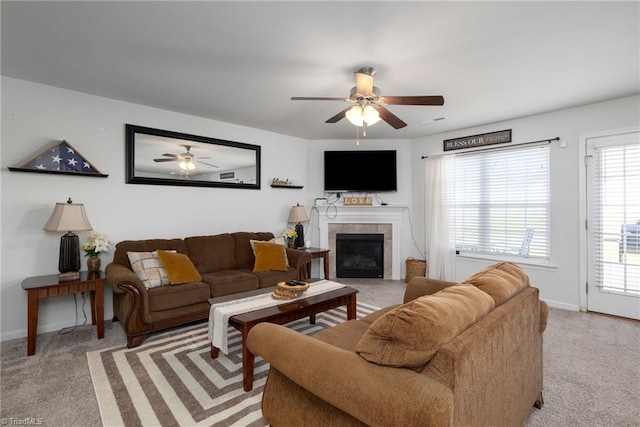 carpeted living room featuring a tile fireplace and ceiling fan