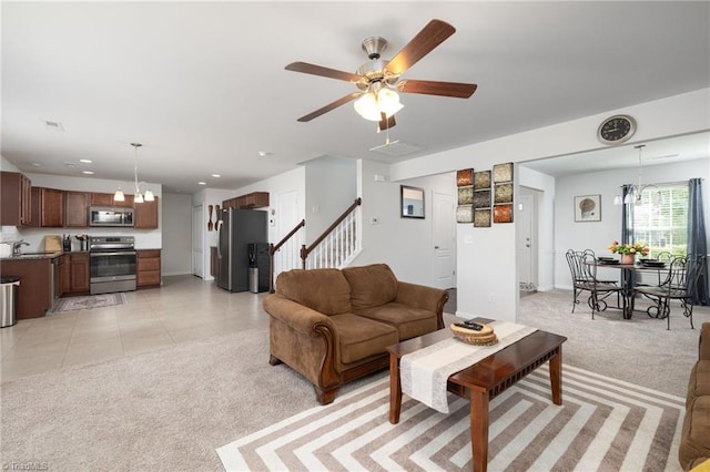 living room with sink, ceiling fan with notable chandelier, and light tile patterned flooring