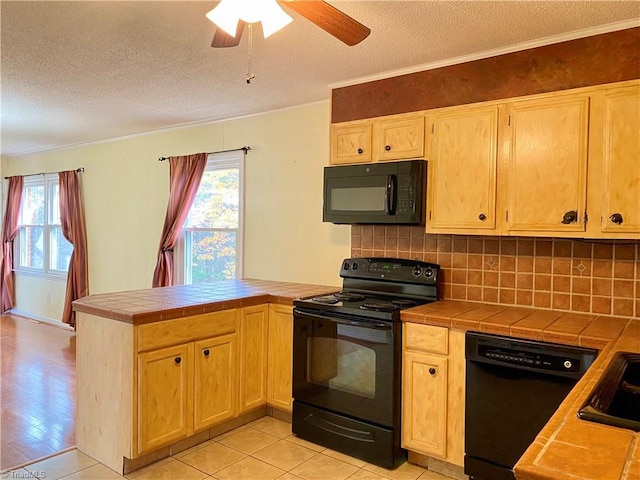 kitchen featuring decorative backsplash, a textured ceiling, black appliances, tile countertops, and light hardwood / wood-style flooring