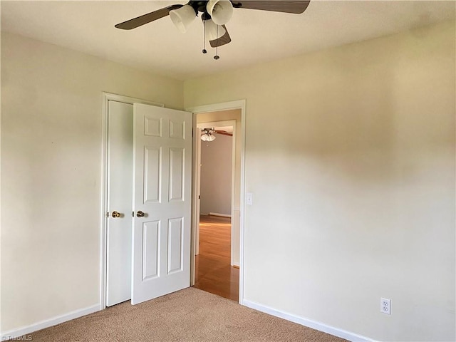 unfurnished bedroom with ceiling fan, carpet floors, and a closet